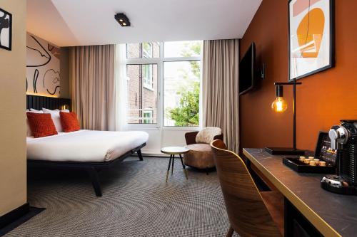 阿姆斯特丹Huygens Place Amsterdam的配有一张床和一张书桌的酒店客房