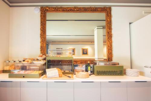 弗留利地区圣达尼埃莱Hotel Residence Dolcenero的厨房内大镜子的台面上方