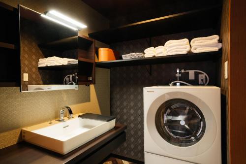 金泽Weskii Hotel的一间带洗衣机和水槽的浴室