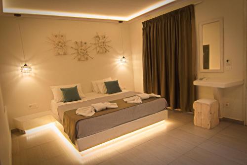 佩里萨海浪酒店的一间卧室配有一张大床和灯光