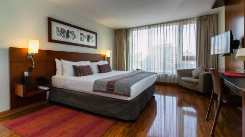 圣地亚哥Select Elegant Apartments by Time Hotel & Apartments的酒店客房设有一张大床和一张书桌。