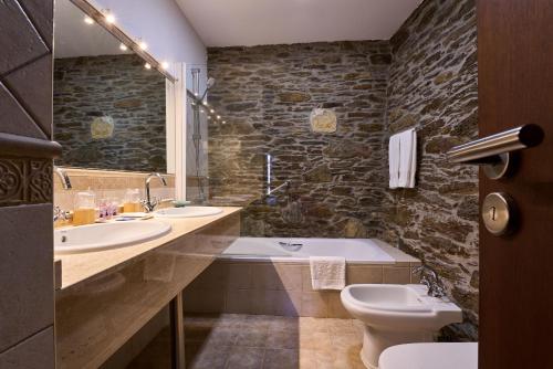 阿尔苏阿Lar da Mota Boutique Hotel的一间带两个盥洗盆、浴缸和卫生间的浴室