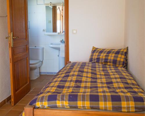 库姆布勒德尔索尔Casa Inca, Villa with heatable pool and top view atop Moraira El Portet的浴室里一张带蓝色和黄色拼盘枕头的床