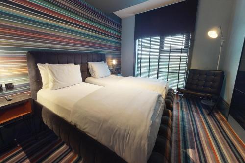 埃尔斯特里伦敦沃特福德乡村酒店的酒店客房设有一张大床和一张书桌。