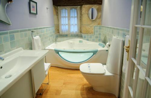 杜鲁埃洛德拉谢拉卡萨罗慕洛酒店的浴室配有卫生间、盥洗盆和浴缸。