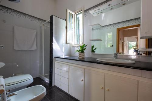 托雷苏达Villa Cielo e Terra by BarbarHouse的一间带水槽、卫生间和镜子的浴室