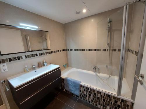 卢森堡Primeurs appartement haut standing de 85 m², Luxembourg-Kirchberg的带浴缸、水槽和淋浴的浴室