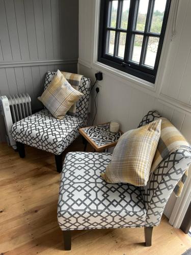 博德明On the Moor Shepherds Huts的客厅配有两把椅子和一张搁脚凳