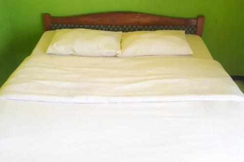 岩望Ambar Tosari Homestay at Desa Wisata Bromo的一张带白色床单的床和两个枕头