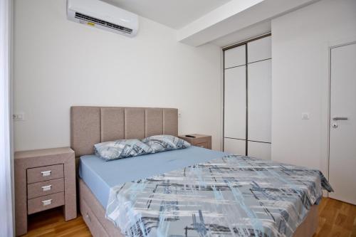 巴尔Lux Stanovi Vucetic的一间卧室设有一张大床和白色的墙壁