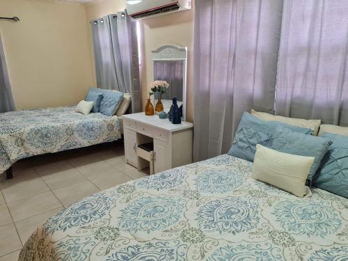 棕榈滩Sandpiper Beach Apartments的一间卧室配有两张床和一张带镜子的桌子