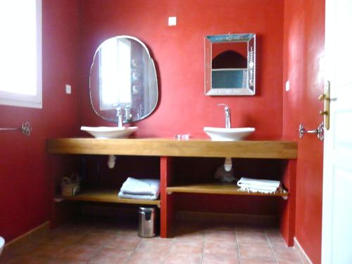 波尔蒂拉盖Un coin de campagne à 4km de la mer pour 4 à 6 personnes的红色的浴室设有两个盥洗盆和镜子