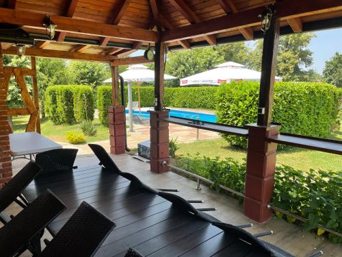 巴尼亚卢卡Family resort TRAPISTI的一个带桌椅的庭院和一个游泳池