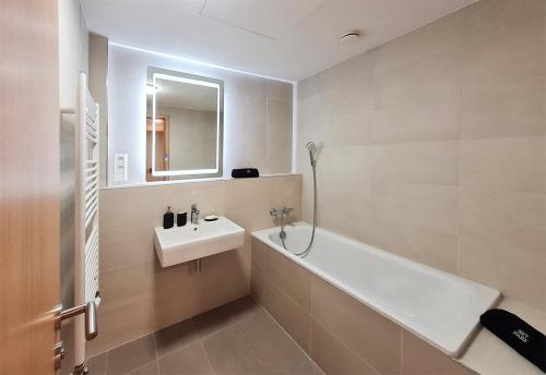 布拉迪斯拉发New modern 2 bedrooms apartment in Bratislava的浴室配有盥洗盆、浴缸和镜子