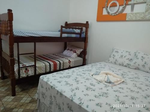伊利亚孔普里达Hospedagem Familiar Yamane的客房设有两张双层床和一张带桌子的床。