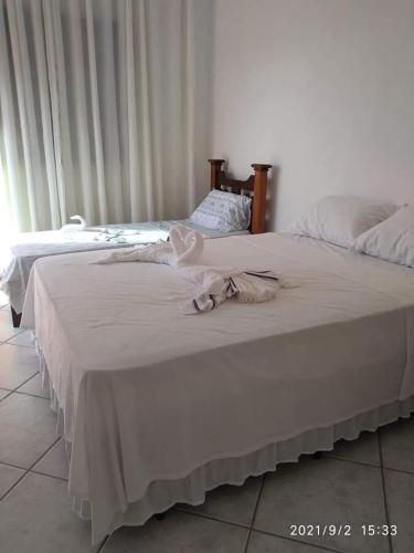 伊利亚孔普里达Hospedagem Familiar Yamane的卧室内的两张床,配有白色床单