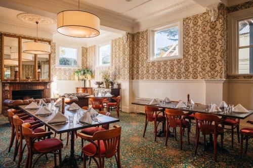 维多利亚山Hotel Etico at Mount Victoria Manor的一间带桌椅和壁炉的用餐室