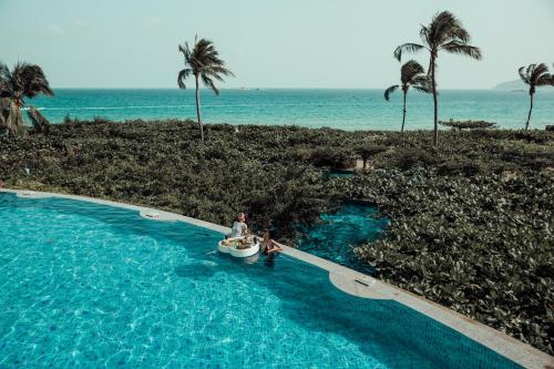 三亚三亚亚龙湾天域度假酒店（接机+林荫泳池）的海滩旁的游泳池里的一个男人
