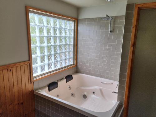 霍尔斯加普D'Altons Studios的带浴缸的浴室和窗户