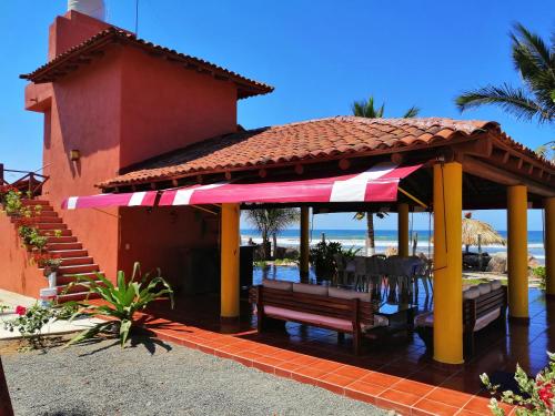 特隆戈内斯Casa La Quinta Ola的凉亭配有长凳和桌椅