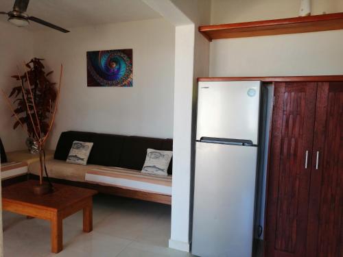 特隆戈内斯Casa La Quinta Ola的客厅配有冰箱和沙发。