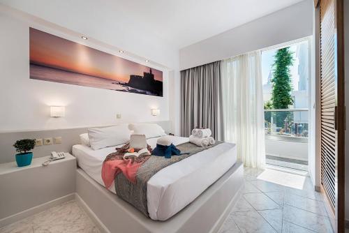 罗德镇Esperia City Hotel的一间卧室设有一张大床和一个大窗户