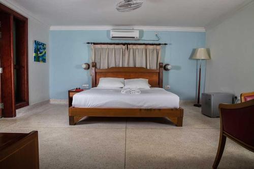 关丹Tanjung Inn的一间卧室配有一张带木制床头板的床