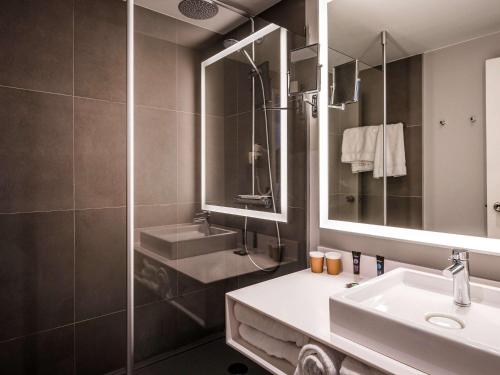 圣让·德·布赖圣让·德·布赖诺富特酒店的一间带水槽、淋浴和镜子的浴室