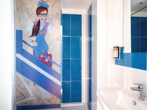 梅里尼亚克greet Hotel Bordeaux Aeroport的浴室在楼梯上画着一位女人的画