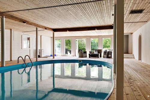 图默利拉Large and beautifully decorated pool house in Tomelilla, Österlen的一座带木制天花板的别墅内的游泳池