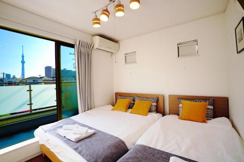 东京Skytree House In Tokyo的带大窗户的客房内的两张床