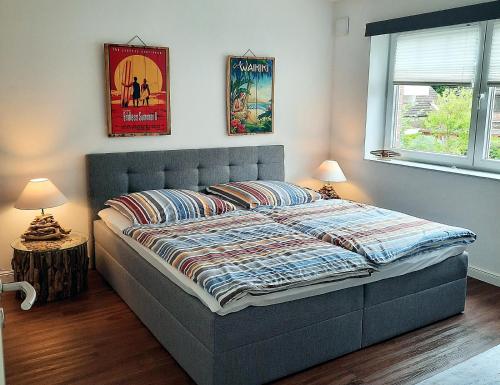 赖因贝克Ferienwohnung Seestern in Reinbek的卧室内的一张床位,配有两盏灯和两张海报