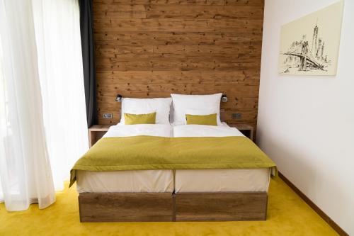 AjkaHotel Kristály Konferencia & Wellness的一间卧室配有一张大床和木制床头板
