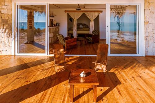 TsifotaAnkasy Lodge的客厅铺有木地板,配有桌椅