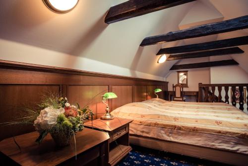 捷克克鲁姆洛夫黄金酒店的一间卧室配有一张大床和木制床头板