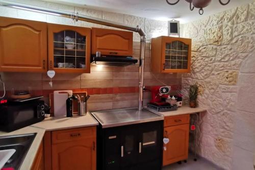 Acquaviva Platani3 bedrooms villa with terrace and wifi at Acquaviva Platani的一个带木制橱柜和水槽的小厨房