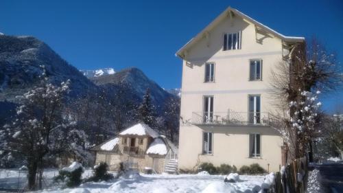 Villeneuve-dʼEntraunesLe Relais des Cavaliers的一座白色的大建筑,地面上积雪