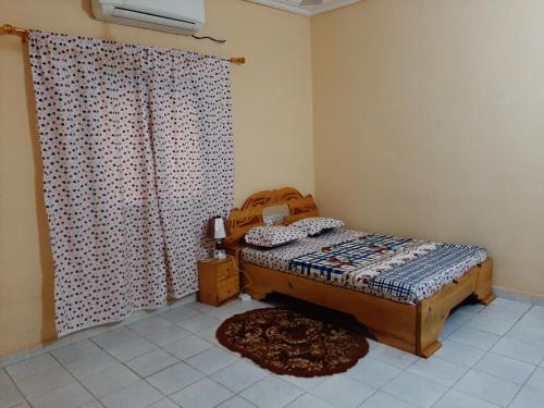 巴马科Appartement Villa的一间卧室配有床、窗帘和地毯