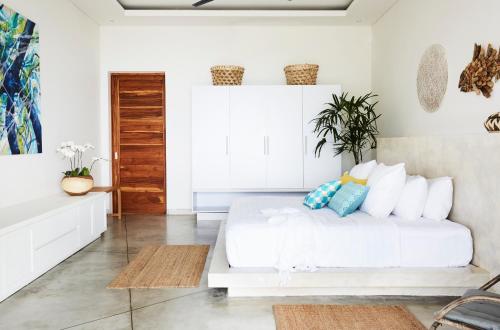 Gili Gede塞拉卢别墅的白色卧室配有白色的床和枕头