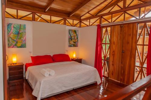 乌维塔Ibiza Tropical Beach Villas的一间卧室配有一张带红色枕头的大床