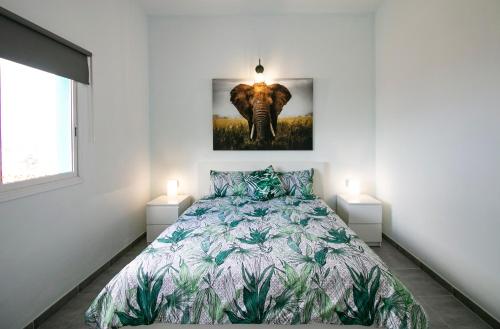 丰卡连特德拉帕尔马Casa Salazar的一间卧室配有一张床,一张大象的照片