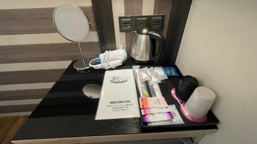 屏东县薇风精品商务旅馆（站前馆） 的一张桌子,位于酒店客房内,配有化妆品和镜子