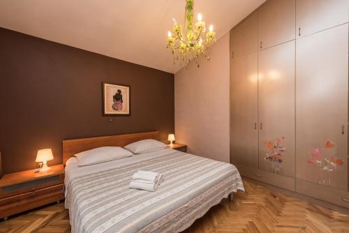 扎达尔Anić House的一间卧室配有一张大床和一个吊灯。