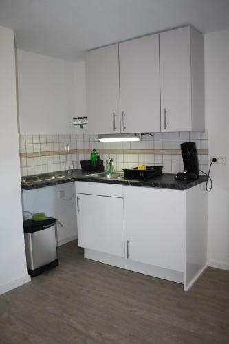 MurgSchönes Zimmer mit Bad für Reisende的厨房配有白色橱柜和台面