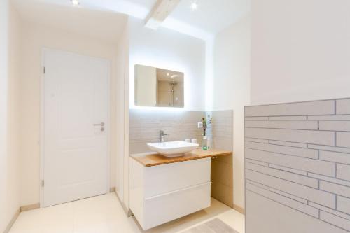 韦耶达Harzfalke Apartment - Ankommen und wohlfühlen.的白色的浴室设有水槽和镜子