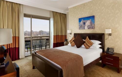 开罗城市之星住桥套房公寓的酒店客房设有一张大床和一个阳台。