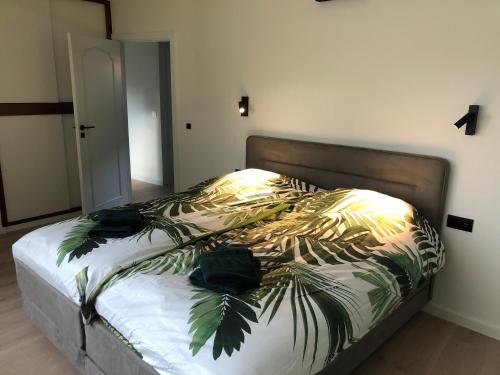 登德尔蒙德ROS'a tourist & business appartment的一间卧室配有一张带棕榈叶床罩的床。