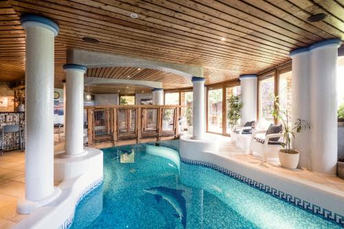 布达佩斯Private Villa with indoor pool的一座带柱子和木制天花板的室内游泳池