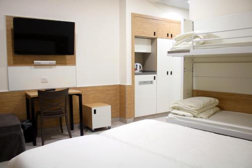 Buqei‘aHI - Pkiin Hostel的一间卧室配有一张床和一张书桌及电视