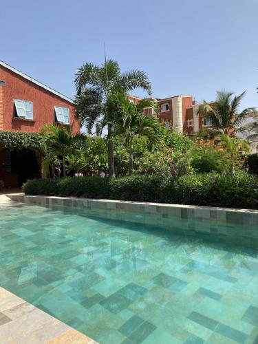 萨利波图尔Villa Aquarêve的棕榈树建筑前的游泳池
